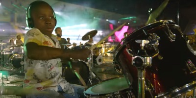 Watch 1,000 People Play David Bowie’s “Rebel Rebel” Together, At The Only Stadium Where Musicians Outnumber The Audience